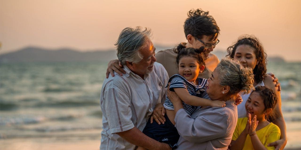 family hugging each other at a beach