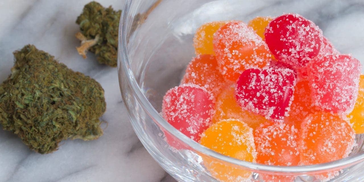 weed chunk beside a bowl of gummies